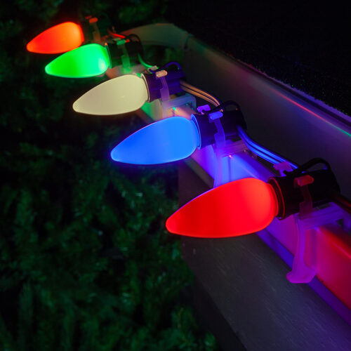 Colorful Christmas lights on a roof with a dark background